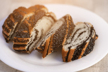 .sliced sweet poppy seed cake on a plate, on a table