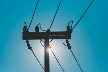 Silhouette wooden electric pole and power lines with sunset in the background at countryside....