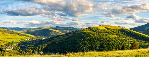  panorama of lovely mountainous area in afternoon. gorgeous cloudscpe on the evening sky. calm and peaceful living in rural area © Pellinni