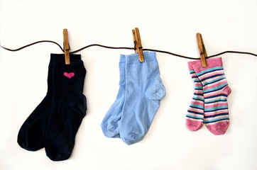 children's colored socks of different sizes weigh on ropes, isolate on a white background