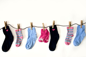 children's colored socks of different sizes weigh on ropes, isolate on a white background