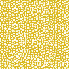 Snowflakes on a gold background seamless vector pattern. White irregular shaped dots. Scattered dots pattern. Perfect as background for Christmas. christmas packaging, cards, gift wrap.