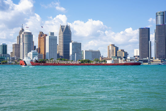DETROIT, MI - AUGUST 18, 2015:  View of barge navigating the Detroit river with General Motors Building and downtown Detroit in the background.