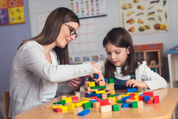 Mother and Daughter Playing Together with colorful building toy blocks