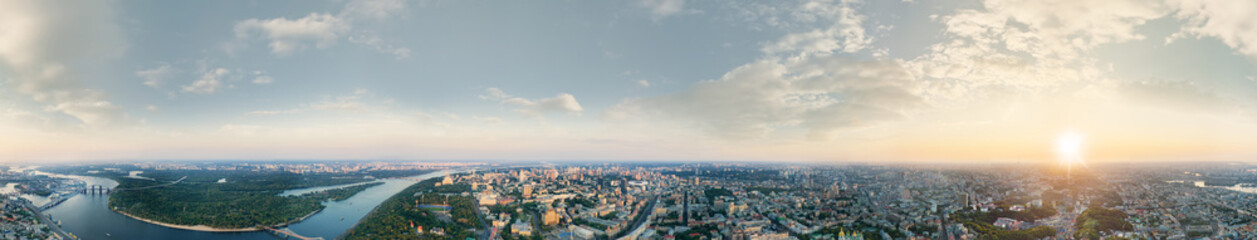 Fototapeta na wymiar A big 360 degrees panorama of the city of Kiev at sunset. A modern metropolis in the center of Europe against the backdrop of sunset sky from a bird's eye view. Aerial view. Panorama of the Tourist