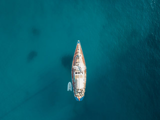 Aerial bird's eye view drone of boat docked in mediterranean tropical beach with turquoise -...