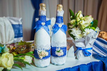 Two decorated champagne bottles on wedding table of newlyweds