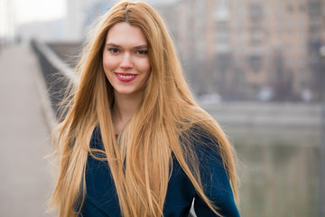 Portrait of a young beautiful woman in blue coat