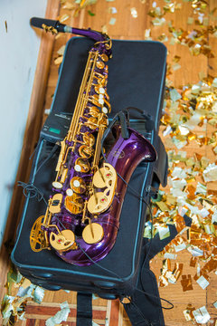 Purple saxophone, with microphone, lies on bag