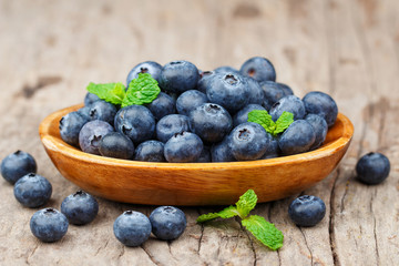 Blueberries in a wood bowl on a wooden table, Healthy eating and nutrition concept