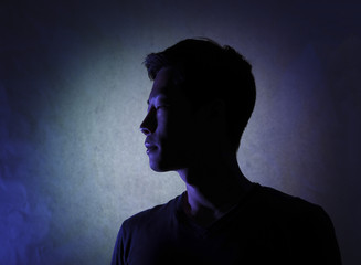 Silhouette of a man deep in thought. A side view of a person who is seriously concerned.