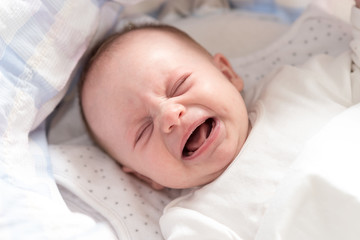 Baby girl crying in her crib © thodonal