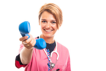 Portrait of female vet wearing pink scrub handing blue receiver.