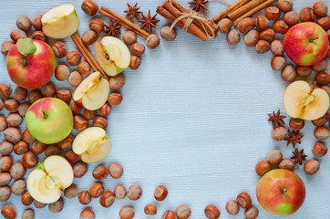 Uncooked tart, fresh apples, hazelnuts and spices - anise stars and cinnamon on the gray kitchen background. Autumn pie with raw ingredients. Top view with copy space for text