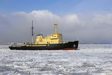 Icebreaker ship breaks ice and moves across the frozen sea