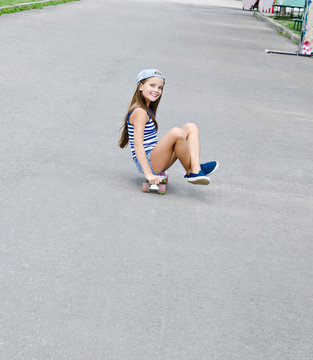 Adorable happy smiling  little girl child with skateboard outdoors