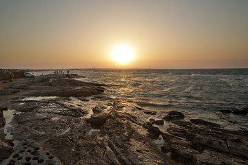 Beautiful sunset at the beach, amazing colors, light beam shining through the cloudscape. Azerbaijan sea and beach . The sound of the sea waves is coming . The fisherman fishes in the sea .