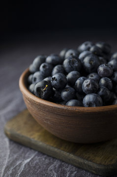 Blueberries in the bowl on a black slate