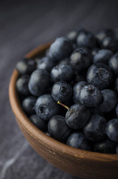 Blueberries in the bowl on a black slate