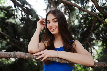 Teenage girl in blue dress posed outdoor at sunny day.