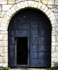 Fototapeta na wymiar Old black metal door in a medieval castle