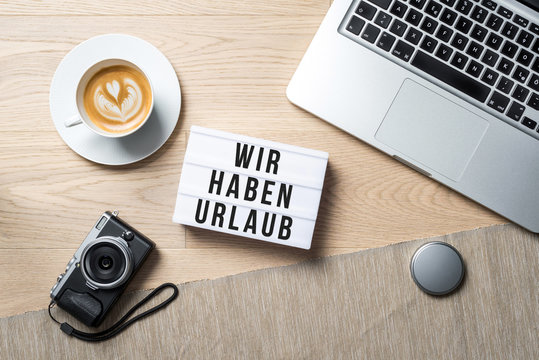 Closed for holidays 2018 written in german on light box as flat lay from above on office desk