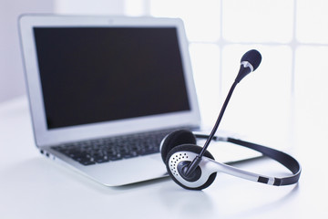 Call center and customer service help desk. VOIP headset on laptop computer keyboard