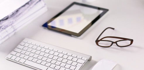 Office table with blank notepad and laptop