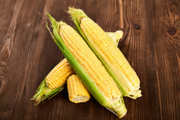 Fresh yellow corn on cobs on rustic wooden table, closeup. Fresh vegetables. Food concept.