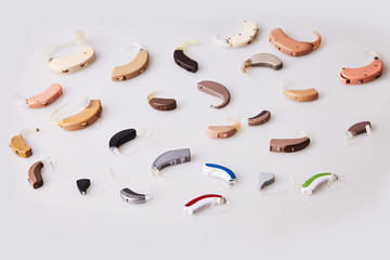 Various hearing aids on white background, alternative to surgery. ENT accessory