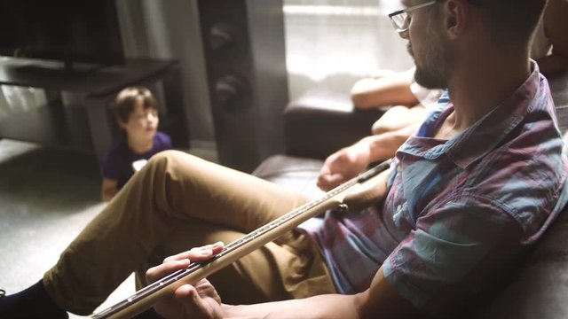 Father plays electric guitar with his children