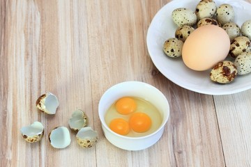 Raw partridge eggs in white bowl /  Quail spotted eggs and chicken egg on white plate for contrast