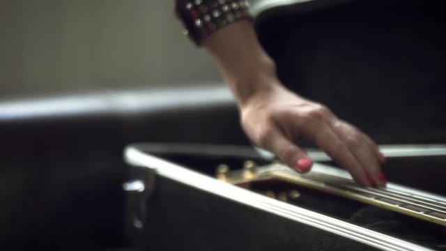The girl takes out the guitar from the case