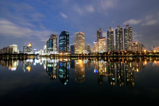 Modern buildings of Benchakitti Park with lights reflection in night city