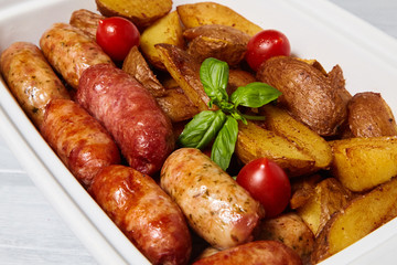 Potatoes with sausages, cut into slices and fried in oil, in rustic style