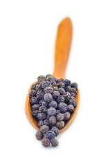 Black pepper on wooden spoon isolated on white background