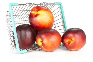 Lot of whole ripe deep red nectarine out of a shopping basket isolated on white