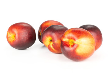 Fototapeta na wymiar Group of five whole ripe deep red nectarine stack isolated on white
