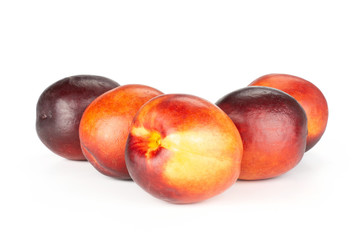Group of five whole ripe deep red nectarine like triangle isolated on white