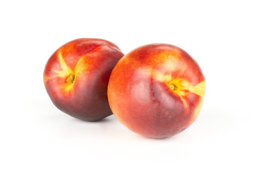 Group of two whole ripe deep red nectarine isolated on white