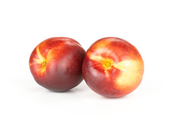 Group of two whole ripe deep red nectarine isolated on white