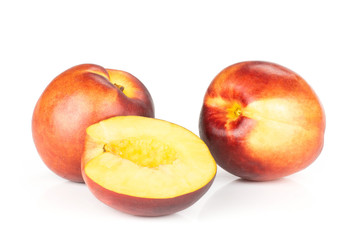 Group of two whole one half of ripe deep red nectarine isolated on white
