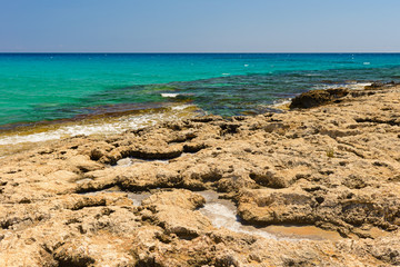 stony coast of the azure sea on a summer sunny day