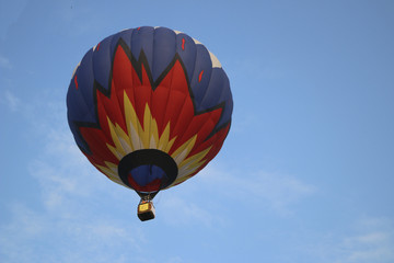 colorful hot air balloon against blue sky. hot air balloon is flying in white clouds. beautiful flying on hot air balloon