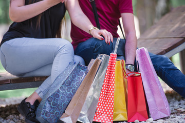 young couple resting at the local park after shopping