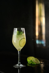cocktail with lime, mint and ice on a black table