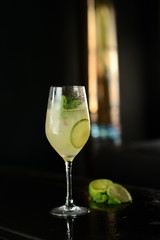 cocktail with lime, mint and ice on a black table
