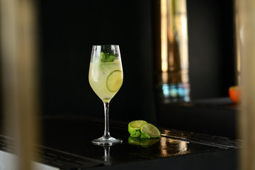 cocktail with lime, mint and ice on a black table