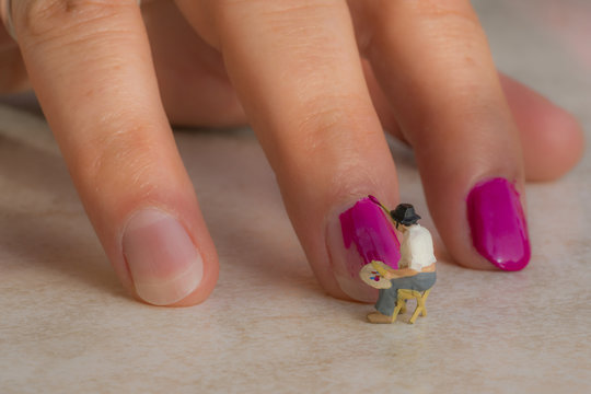 Junge Frau lässt sich von kleinem Künstler die Fingernägel lackieren