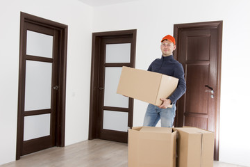 Relocation services man with cardboardboxes. Worker transporting things in the apartment. Moving to a new house concept. Mover with cardboardbox.